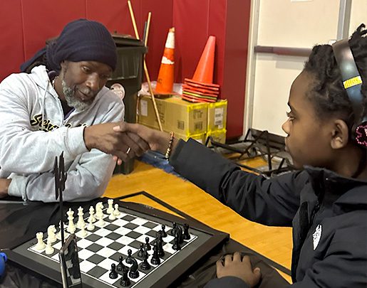 Chess instructor and child playing chess