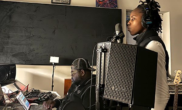 Young girl singing in recoding studio with music engineer